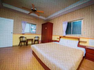 a bedroom with a bed and a table and chairs at Xiaoye Liu Homestay in Guoxing