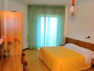 a bedroom with a bed and a vase of flowers at Hotel El Senor in Pretoro