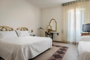 a bedroom with two beds and a flat screen tv at Eurostars Centrale Palace Hotel in Palermo +84 photos