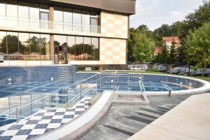 a swimming pool in front of a building at Hotel President SPA in Baile Felix