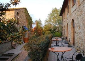 patio ze stołami i krzesłami na dziedzińcu w obiekcie Agriturismo Fattoria Lischeto w mieście Volterra