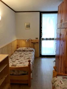 マドンナ・ディ・カンピリオにあるMaso Appartamentoの小さなベッドルーム(ベッド1台、窓付)