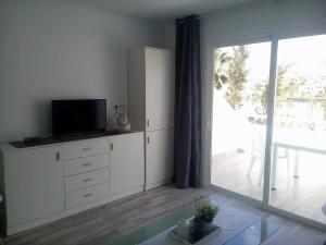 a living room with a tv and a large sliding glass door at Apartment Island Paradise in Adeje