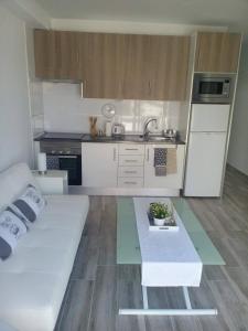 a living room with a white couch and a kitchen at Apartment Island Paradise in Adeje