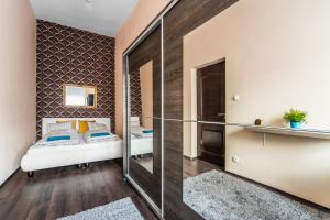 1 dormitorio con espejo y 1 cama en una habitación en KIRÁLY 38 2BEDROOM AIRCON ENTIRE APARTMENT, en Budapest