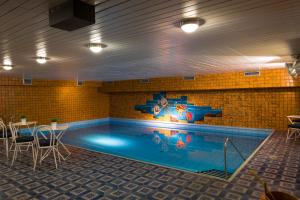 a swimming pool with a mural on the wall at Kleinhuis Hotel Mellingburger Schleuse in Hamburg