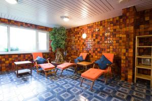 a room with chairs and tables and a brick wall at Kleinhuis Hotel Mellingburger Schleuse in Hamburg