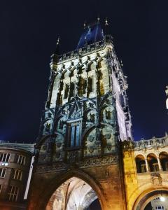 a building with a clock tower at night at Apartment Aida in Prague
