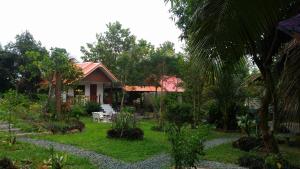 Areeya Resort في Watthana Nakhon: منزل أمامه حديقة