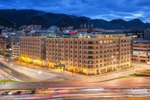 a large building in a city at night at Casa Dann Carlton Hotel & SPA in Bogotá