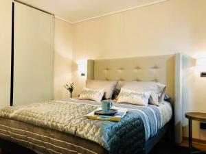 a bedroom with a large bed with a tray on it at Apartamentos El Golf Las Condes in Santiago