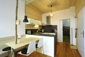 a kitchen with a wooden table and white chairs at Gästehaus Zweite Heimat in Rhodt unter Rietburg