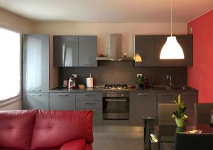 un soggiorno con divano rosso in cucina di Casa Diso 2016 a Vittorio Veneto