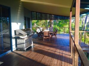 een afgeschermde veranda met een grill en een tafel bij The Holiday House in Fraser Island