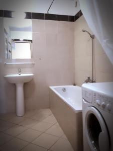 y baño con lavabo y lavadora. en Gozsdu Suite Apartment, en Budapest