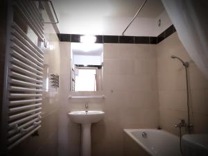 y baño con lavabo y bañera. en Gozsdu Suite Apartment, en Budapest