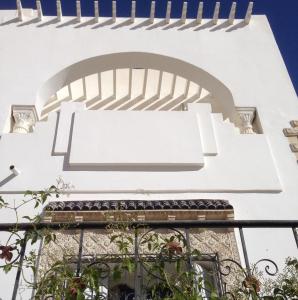 un edificio blanco con ventana y arco en Dar Ezzahra en Tozeur