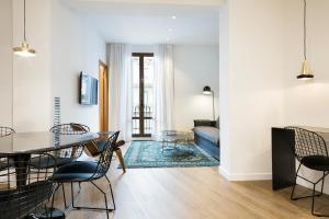 Vale Suites في برشلونة: غرفة معيشة مع طاولة وكراسي وأريكة
