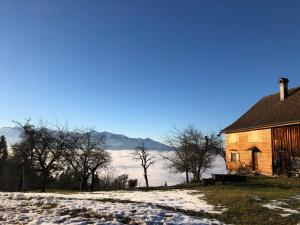 an old barn with snow on the ground next to a lake at Feriendomizil Suldis in Batschuns