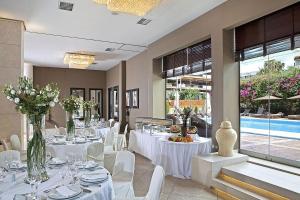a dining room with white tables and white chairs at Congo Palace in Athens