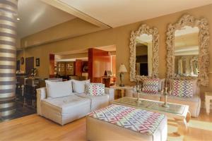 a living room with two white couches and mirrors at Congo Palace in Athens