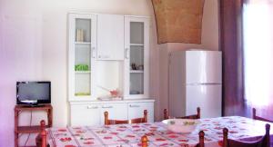 una cucina con tavolo e frigorifero bianco di Villa "Franca" a Porto Cesareo