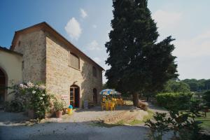 een gebouw met een tafel en stoelen ervoor bij Villaggio Turistico Camping Il Fontino in Scarlino