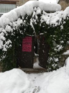 a building covered in snow with a sign on it at Guest House Ioanna Arachova in Arachova