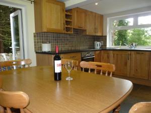 キラーニーにあるThe Reeks Cottageの木製テーブルに座ったキッチンのワイン1本