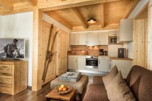 a living room with a couch and a kitchen at AlpenParks Hagan Lodge Altaussee in Altaussee