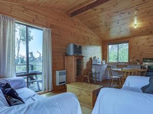 a log cabin with a kitchen and a living room at Steeles Island Retreat in Carlton