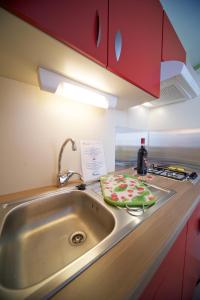 a kitchen counter with a sink and a bottle of wine at Villaggio Turistico Camping Il Fontino in Scarlino