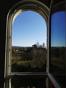 uma janela aberta com vista para um campo em Le Grenier em Les Ageux