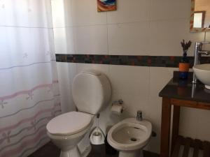 a bathroom with a toilet and a sink at Cabañas El Ocio in Punta Del Diablo