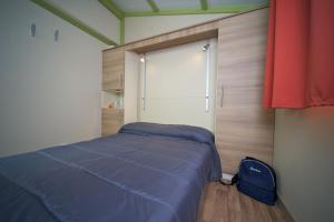 een kleine slaapkamer met een bed en een raam bij Villaggio Turistico Camping Il Fontino in Scarlino