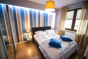 Una cama o camas en una habitación de Apartamenty Sun & Snow Zielony Zdrój