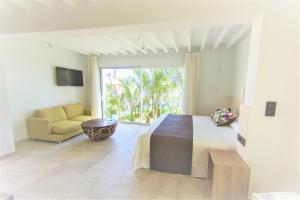 a bedroom with a bed and a couch and a window at Botaniq Hotel Boutique in Mojácar