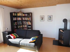a living room with a couch and a book shelf at Ferienwohnung Hübner in Brandenberg