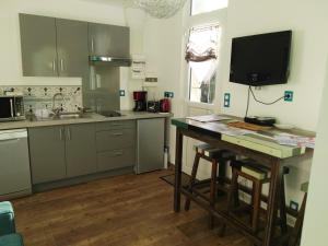 a kitchen with a table and a television in it at Le Presbytère in Les Ageux