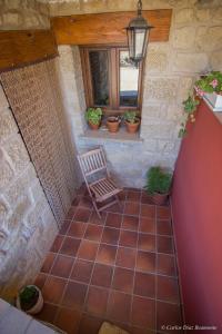 un patio con una silla, una ventana y macetas en Atardeceres d'Aragón, en Fontellas
