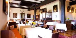 a dining room with white tables and chairs with flowers on them at Schloss Weitenburg in Starzach