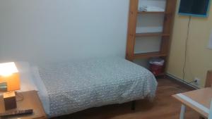 a bedroom with a bed and a book shelf at Pension Santa Rita in Santiago de Compostela