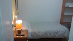 a bedroom with a bed and a lamp on a night stand at Pension Santa Rita in Santiago de Compostela
