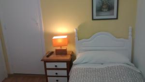 a bedroom with a bed and a lamp on a night stand at Pension Santa Rita in Santiago de Compostela