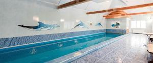 - une piscine dans une maison avec des dauphins sur le mur dans l'établissement Podolyanka, à Slavsko
