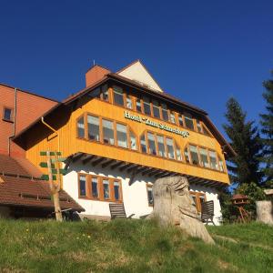 ein großes Gebäude mit einem Schild an der Seite in der Unterkunft Hotel Zum Schneekopf "Garni" in Gehlberg
