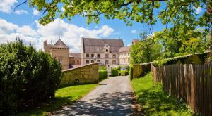 una casa con una valla y un camino de tierra en Schloss Weitenburg en Starzach