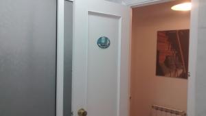 a bathroom with a door with a clock on it at Pension Santa Rita in Santiago de Compostela