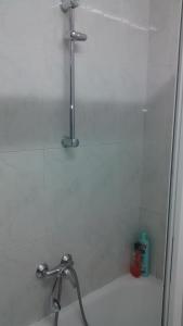 e bagno con doccia e vasca bianca. di Pension Santa Rita a Santiago de Compostela