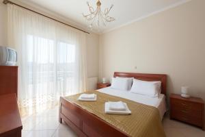 a bedroom with a bed with two towels on it at Family apartment near the sea in Kremasti